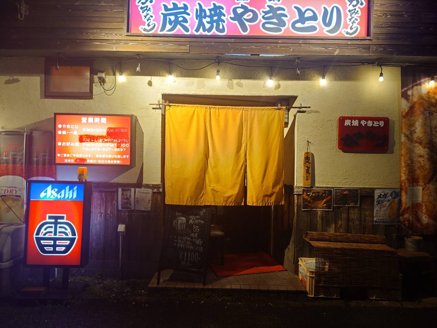 炭焼やきとり かみなりの店舗外観（黄色い暖簾と赤い看板）
